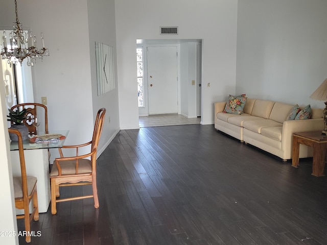 living room with dark hardwood / wood-style flooring and a chandelier