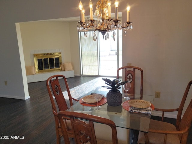 dining room featuring dark wood-type flooring and a tiled fireplace