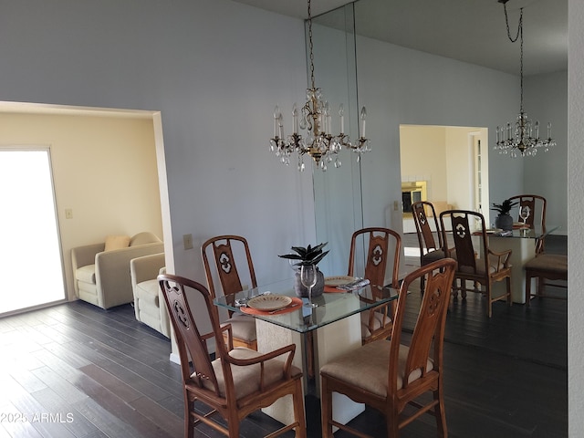 dining room with dark hardwood / wood-style floors and a notable chandelier