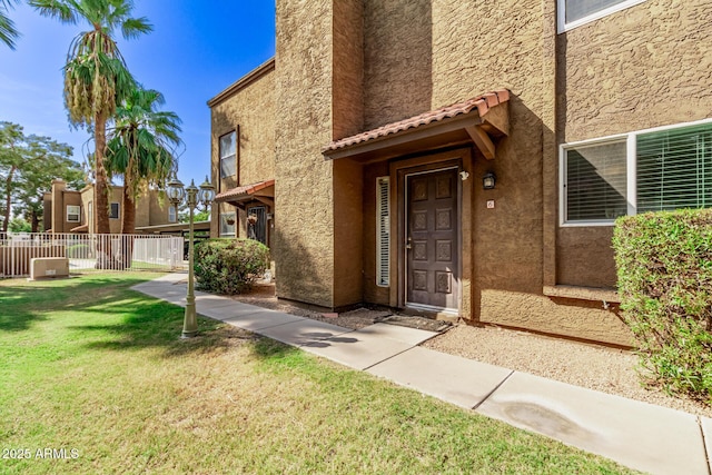 view of exterior entry with a lawn