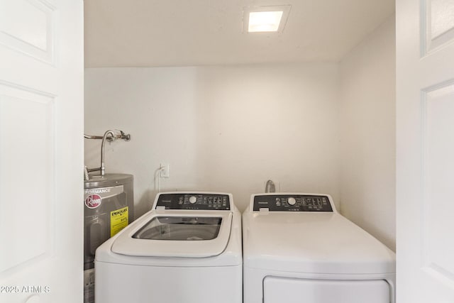 laundry room with electric water heater and washer and dryer