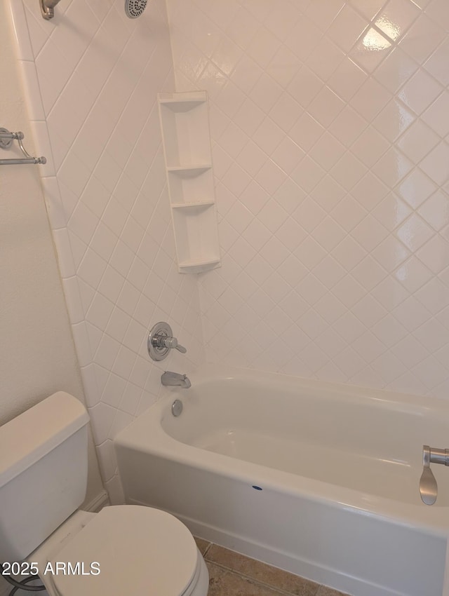 bathroom featuring tile patterned floors, tiled shower / bath combo, and toilet