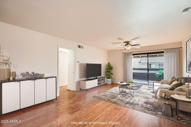 living room featuring ceiling fan, a textured ceiling, and hardwood / wood-style flooring