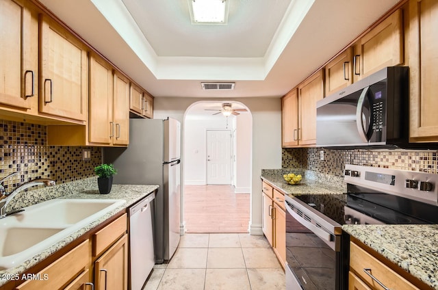 kitchen with ceiling fan, sink, backsplash, light tile patterned floors, and appliances with stainless steel finishes