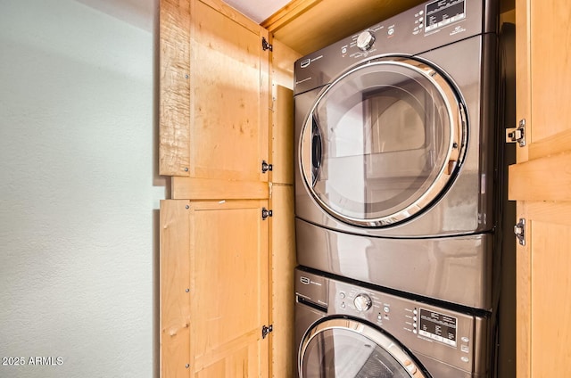 clothes washing area featuring stacked washer / dryer