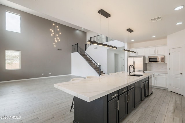 694 W Desert Seasons Dr, San Tan Valley, AZ 85143 - kitchen featuring appliances with stainless steel finishes, white cabinetry, light wood-style floors, and recessed lighting