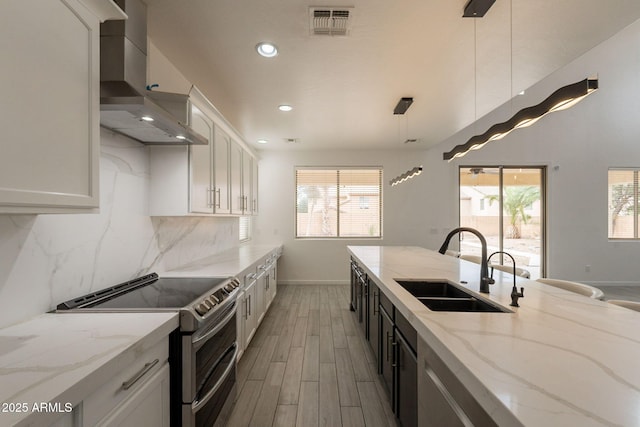 694 W Desert Seasons Dr, San Tan Valley, AZ 85143 - kitchen featuring double oven range, wall chimney exhaust hood, tasteful backsplash, light wood-type flooring, and healthy amount of natural light