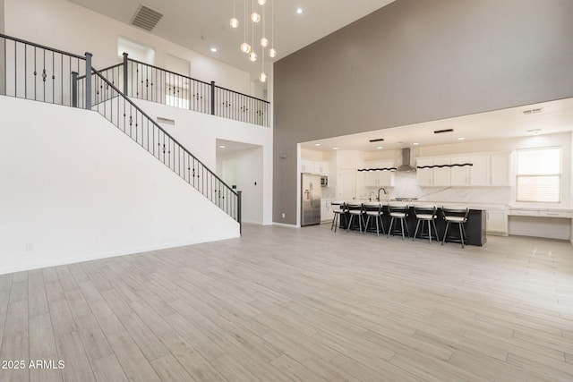 694 W Desert Seasons Dr, San Tan Valley, AZ 85143 - living area with a towering ceiling, light wood-style floors, recessed lighting, and stairway