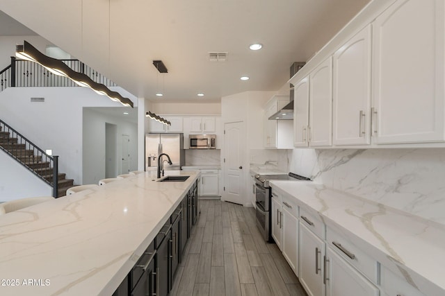 694 W Desert Seasons Dr, San Tan Valley, AZ 85143 - kitchen with stainless steel appliances, recessed lighting, white cabinets, backsplash, and wall chimney exhaust hood
