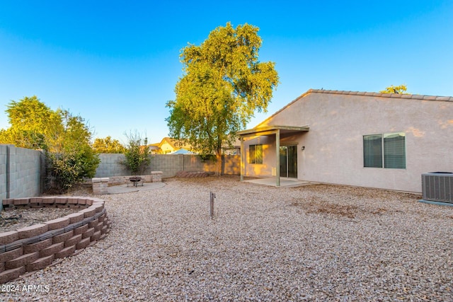 rear view of house featuring a patio, central AC unit, a fenced backyard, and stucco siding