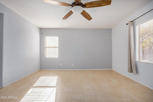 unfurnished room featuring ceiling fan and baseboards