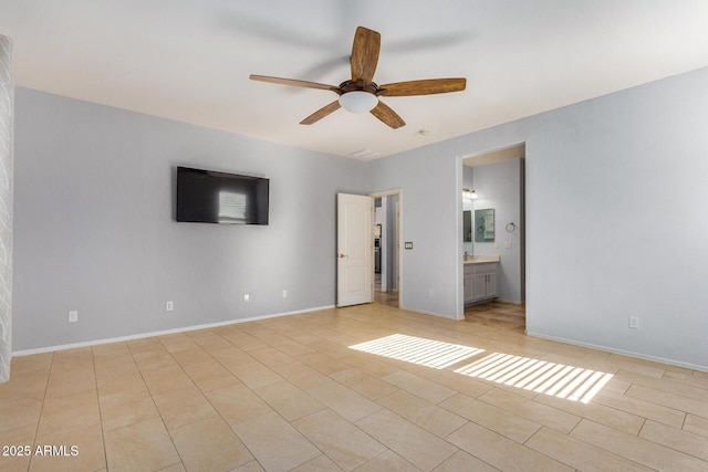 unfurnished bedroom with light tile patterned floors, ensuite bath, and baseboards