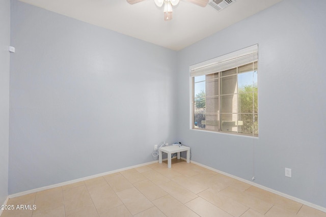 empty room featuring a ceiling fan, light tile patterned flooring, visible vents, and baseboards