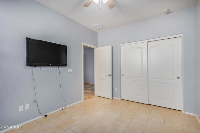 unfurnished bedroom with baseboards, ceiling fan, visible vents, and a closet