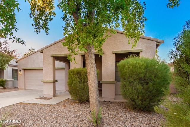 view of front of house with driveway, a garage, and stucco siding