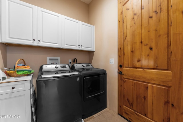 washroom featuring washer and clothes dryer and cabinets