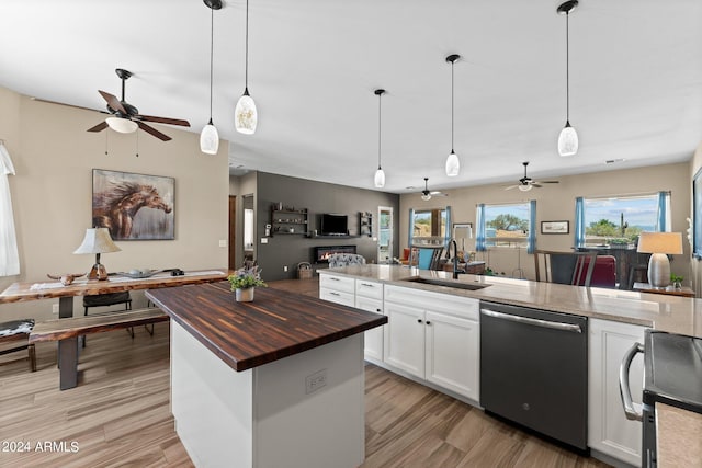 kitchen featuring hanging light fixtures, white cabinets, sink, dishwasher, and a kitchen island