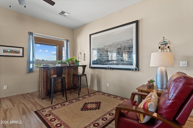 sitting room with ceiling fan and light wood-type flooring