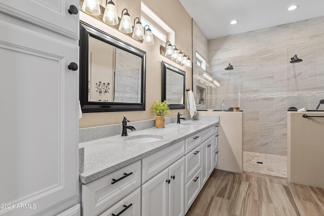 bathroom with vanity and a tile shower