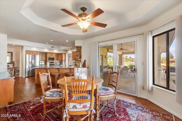 18738 E Buckskin Dr, Rio Verde, AZ 85263 - dining room featuring a ceiling fan, dark wood-style flooring, a raised ceiling, and baseboards