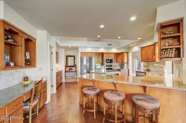 18738 E Buckskin Dr, Rio Verde, AZ 85263 - kitchen featuring stainless steel appliances, a sink, open shelves, wood finished floors, and light stone counters