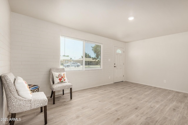 living area featuring baseboards and light wood-type flooring