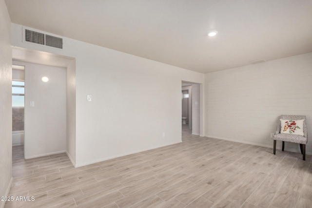 empty room featuring visible vents, baseboards, and light wood-type flooring