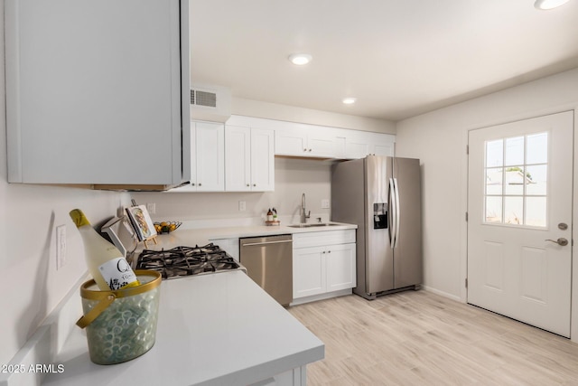 kitchen with visible vents, appliances with stainless steel finishes, light countertops, and a sink