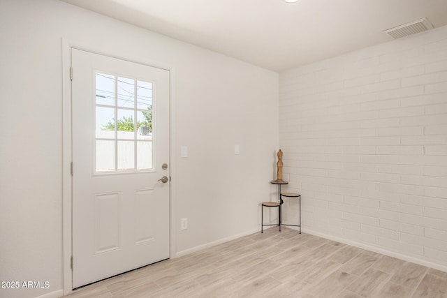 entryway with baseboards, visible vents, and light wood-type flooring