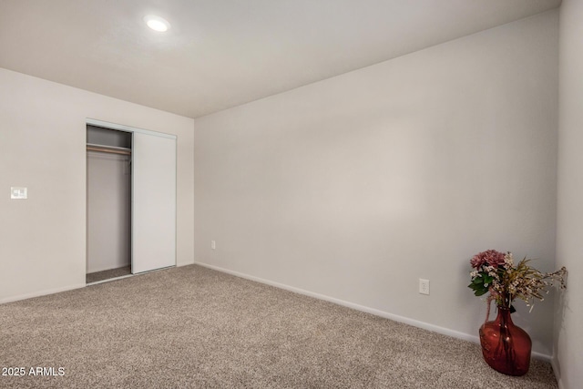 unfurnished bedroom with baseboards, recessed lighting, carpet floors, and a closet