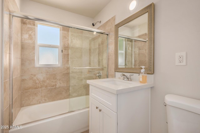 bathroom with combined bath / shower with glass door, vanity, and toilet