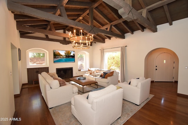 living room featuring beamed ceiling, a chandelier, hardwood / wood-style flooring, and wooden ceiling