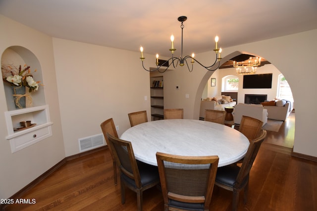 dining area with dark hardwood / wood-style flooring and a chandelier