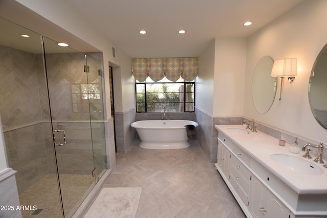 bathroom with vanity, separate shower and tub, parquet floors, and tile walls