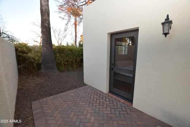 view of exterior entry featuring a patio area