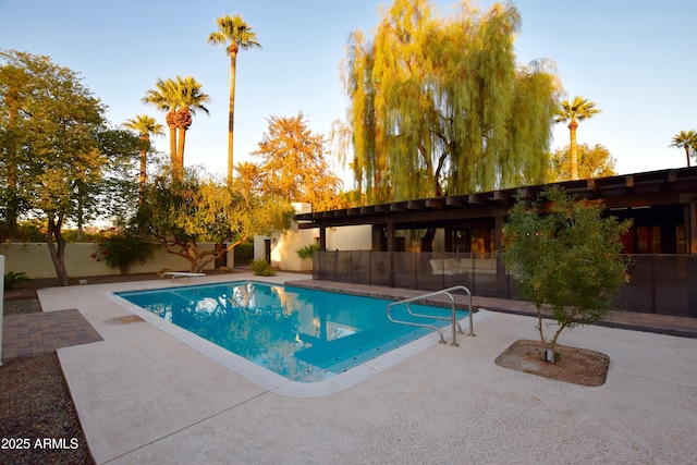 view of swimming pool with a diving board and a patio