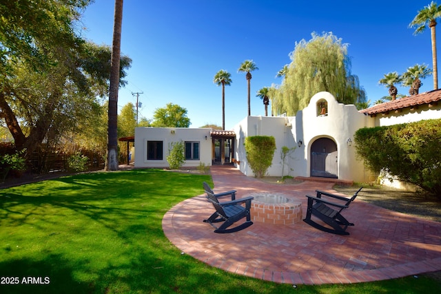 rear view of house with a lawn and a patio area