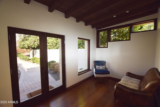 interior space with vaulted ceiling with beams and dark hardwood / wood-style floors