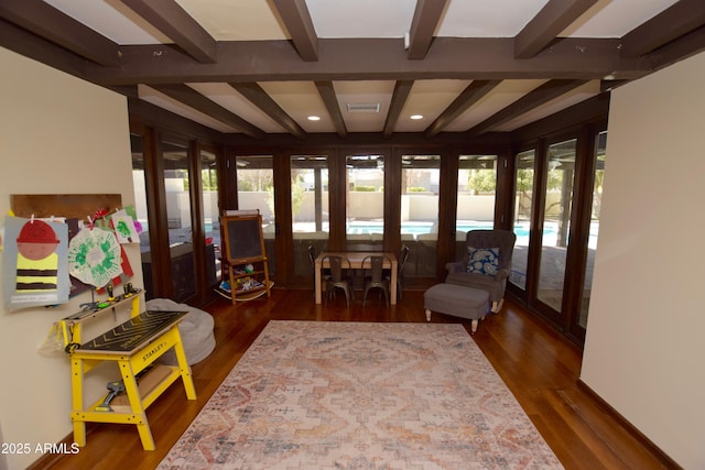 sunroom with beam ceiling, plenty of natural light, and french doors