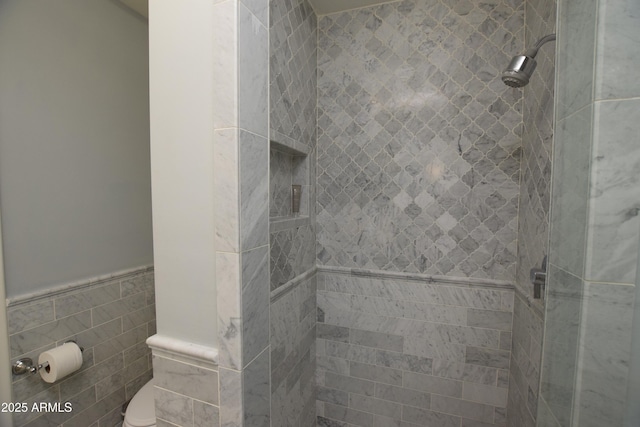 bathroom with tiled shower, tile walls, and toilet