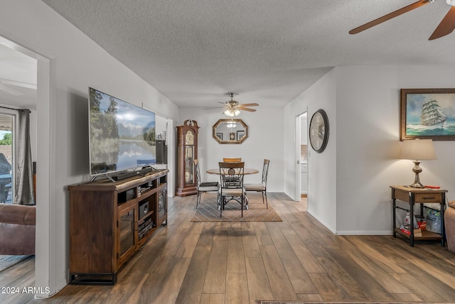 dining room featuring ceiling fan, dark wood-type flooring, and a textured ceiling