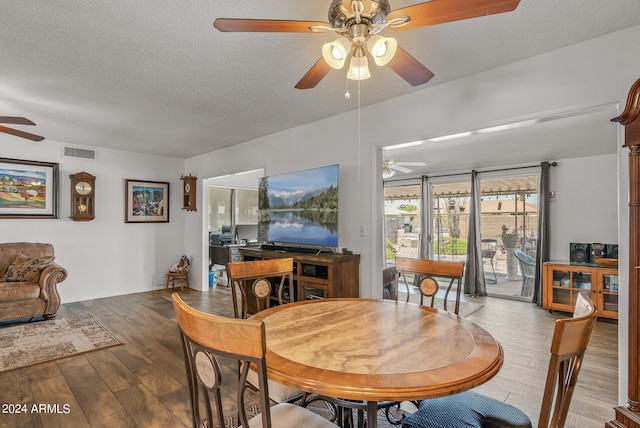 dining area with hardwood / wood-style floors and a textured ceiling