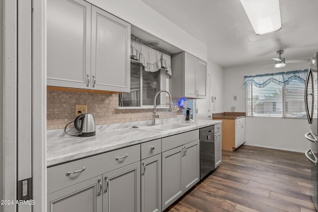 kitchen with stainless steel dishwasher, gray cabinetry, ceiling fan, sink, and dark hardwood / wood-style floors