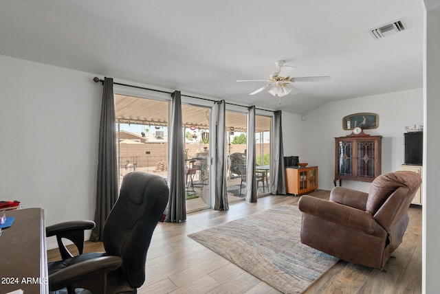 living room with light hardwood / wood-style floors, vaulted ceiling, plenty of natural light, and ceiling fan