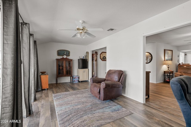 living area with ceiling fan and dark hardwood / wood-style flooring