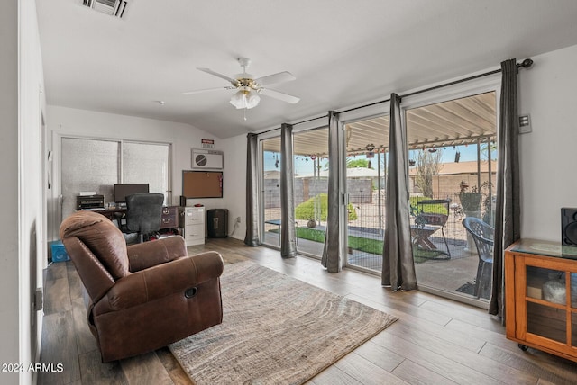 living room featuring ceiling fan, hardwood / wood-style floors, and vaulted ceiling