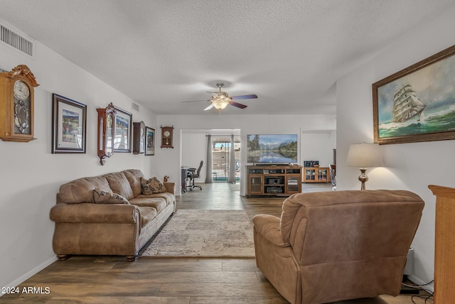 living room with hardwood / wood-style floors, ceiling fan, and a textured ceiling