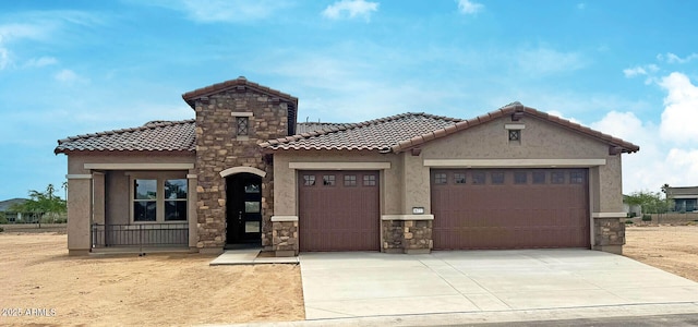 16777 W Sheila Ln, Goodyear, AZ 85395 - mediterranean / spanish home with an attached garage, a tile roof, stucco siding, driveway, and stone siding