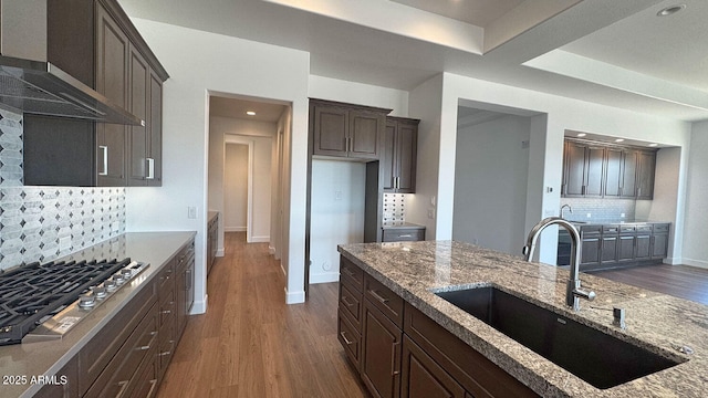 16777 W Sheila Ln, Goodyear, AZ 85395 - kitchen featuring stainless steel gas cooktop, wall chimney range hood, dark wood-type flooring, light stone countertops, and recessed lighting