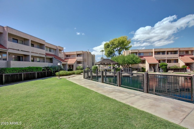 view of home's community featuring a residential view, fence, a gazebo, and a lawn